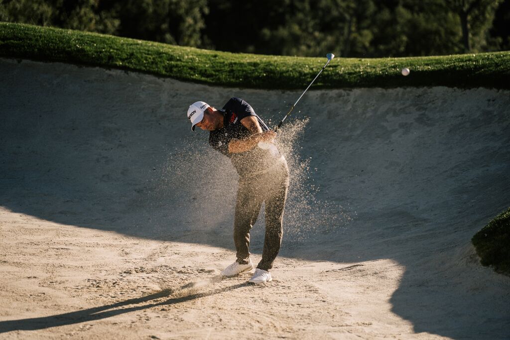 Professional golfer with Cleveland wedge on course